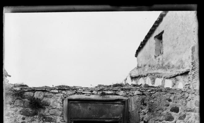 Restes dun edifici a Palau-solità i Plegamans. Finestra i escut de teixidor a la llinda de pedra de la porta