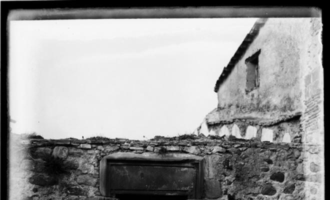 Restes dun edifici a Palau-solità i Plegamans. Finestra i escut de teixidor a la llinda de pedra de la porta