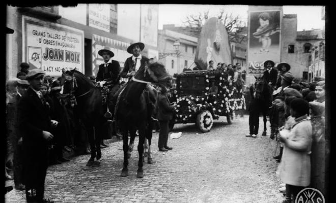 Carrossa i comparses de la cavalcada de Carnestoltes al seu pas per la plaça de l'Àngel. Sabadell
