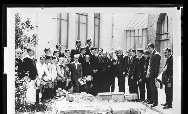 Joan Vila Cinca explicant la procedència d'unes pedres pel futur Museu d'Història de Sabadell als components de la Congregació Mariana. Pati de l'Escola Industrial de Sabadell