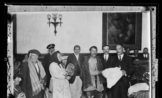 Repartiment de roba als pobres per part dels senyors Vicenç Mayor i Josep Roure membres de l' Acadèmia Catòlica. Alberg del pobre de Sabadell