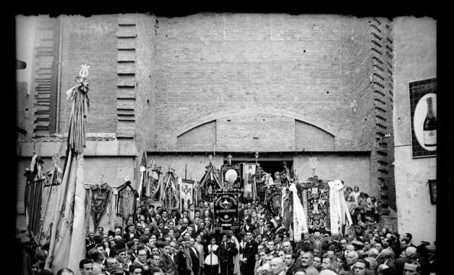 Concentració d'estendards i banderes dels cors populars d'en Clavé davant de la porta de l'església de Sant Feliu. Sabadell
