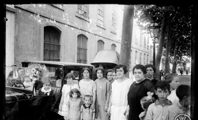 Grup de dones i nens davant de la fàbrica Morral de la Rambla de Sabadell el dia de Sant Cristòfol. Sabadell