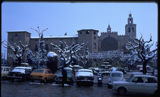 Pancarta dels treballadors de la Manufactura Aymat penjada sobre la plaça d'Octavià nevada.