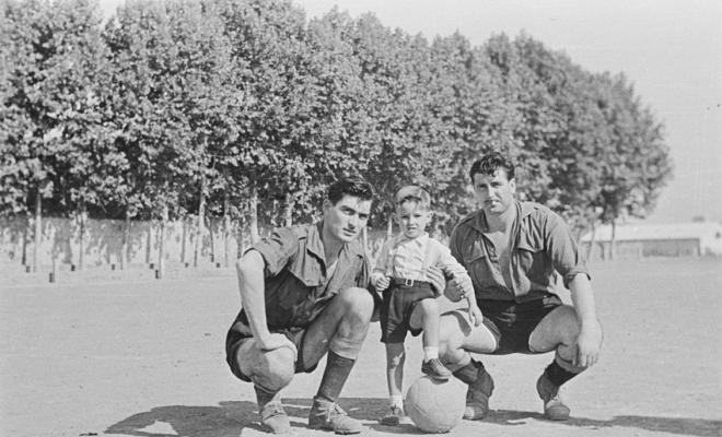 Retrat d'un infant amb dos futbolistes, a l'antic camp de futbol situat al recinte del Monestir.