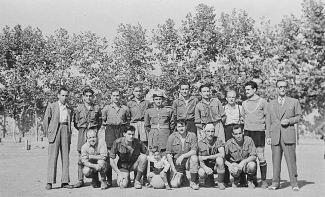 Retrat de grup, jugadors de l'equip de futbol acompanyats d'altres homes, d'un infant i d'un membre de la Guàrdia civil.