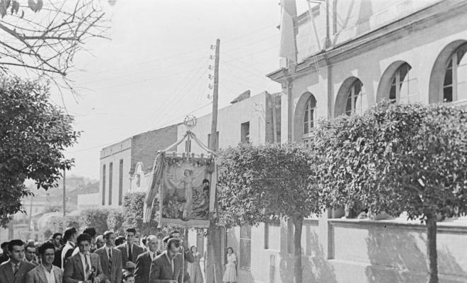 Actes de la festa inaugural de la restaurada Societat Coral La Unió Santcugatenca. Arribada dels socis i assistents al carrer de la Unió, seguint pel portador de l'estendard Pere Pahisa.