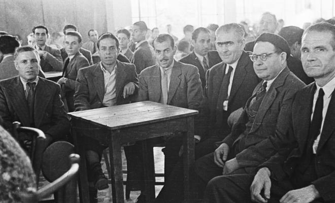 Actes de la festa inaugural de la restaurada Societat Coral La Unió Santcugatenca. Un grup d'homes asseguts, a la sala del cafè de la Unió.