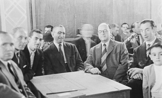 Actes de la festa inaugural de la restaurada Societat Coral La Unió Santcugatenca. Un grup d'homes asseguts, a la sala del cafè de la Unió.