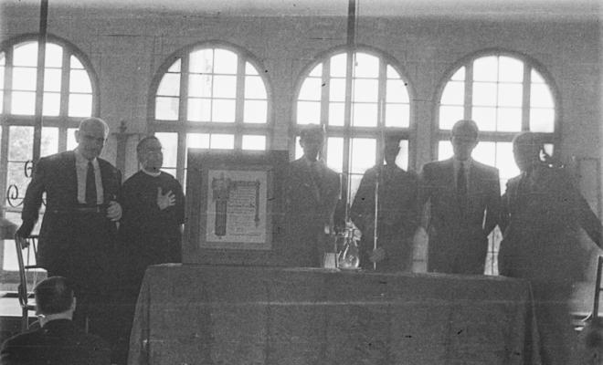 Actes de la festa inaugural de la restaurada Societat Coral La Unió Santcugatenca. Lliurament d'un pergamí - recordatori emmarcat al mossèn.