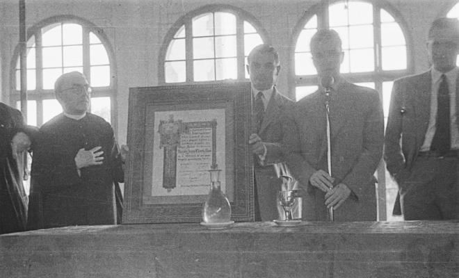 Actes de la festa inaugural de la restaurada Societat Coral La Unió Santcugatenca. Lliurament d'un pergamí - recordatori emmarcat al mossèn.