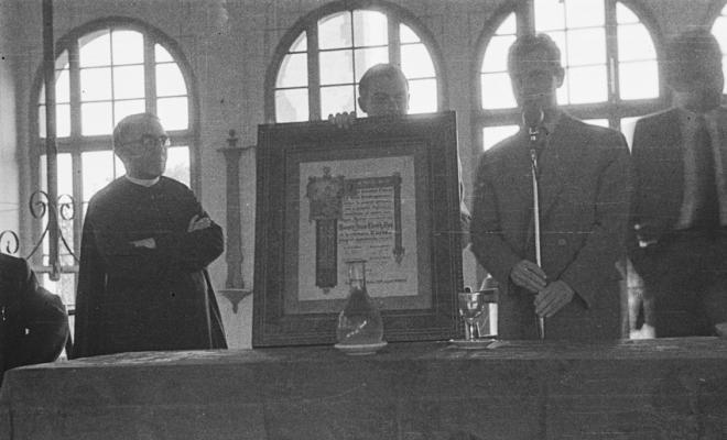 Actes de la festa inaugural de la restaurada Societat Coral La Unió Santcugatenca. Lliurament d'un pergamí - recordatori emmarcat al mossèn.