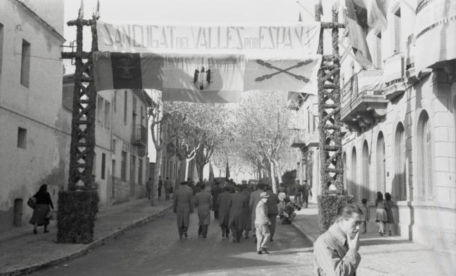 Acte politicoinstitucional, arcada amb les banderes del moviment falangista i la bandera preconstitucional, davant de la seu de la Falange a Cal Barbany. 