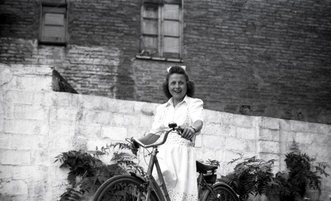 Dona en bicicleta retratada al pati del fotògraf.
