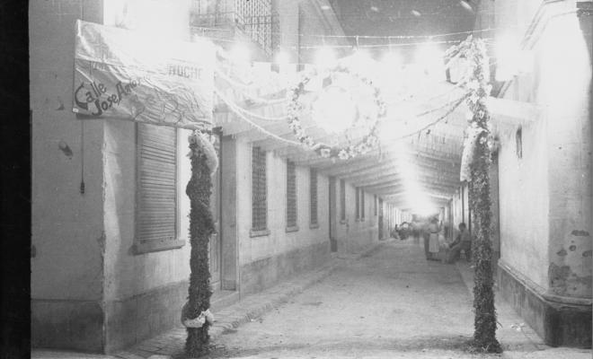 Carrer de Xerric, de nit, engalanat amb motiu d'unes festes.