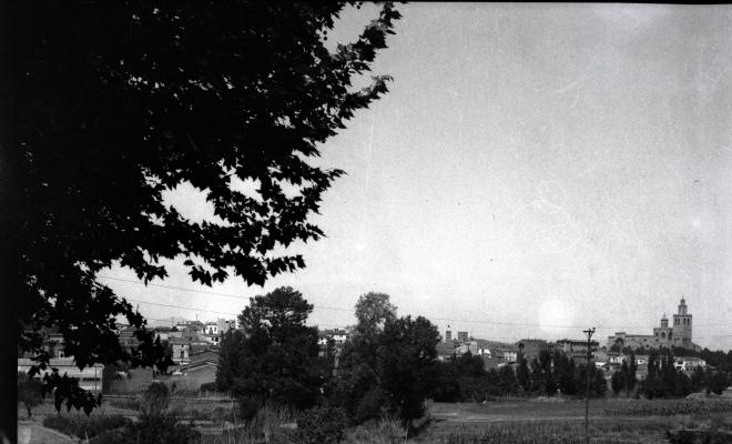 Vista del Monestir i el nucli de la vila, des dels horts de la masia de Can Ganxet de la Riera.