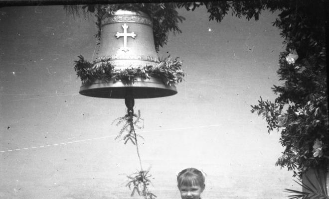 Festa de Sant Antoni Abat. Una nena enfilada en una cadira a punt de fer sonar la campana.