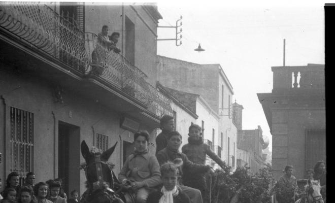 Festa de Sant Antoni Abat. Retrat de un grup de joves dalt d'un carro al seu pas per la plaça de Barcelona.