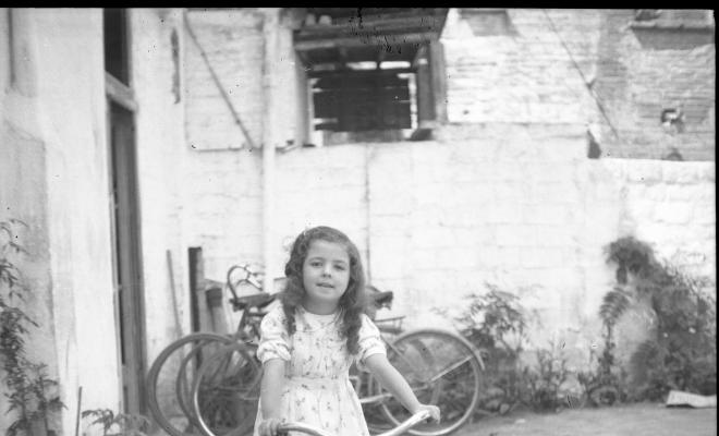Retrat de l'Elisabet  Cabanas sobre una bicicletaque du un sidecar de vímet.