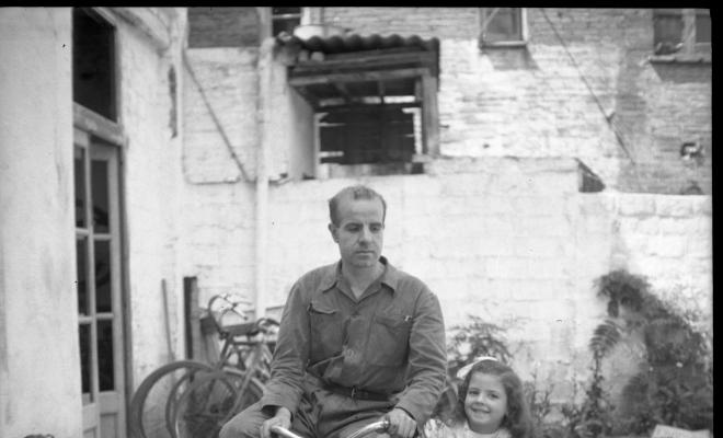Retrat del Joan Cabans en bicicleta i de l'Elisabet asseguda en el sidecar de vímet d'aquesta.