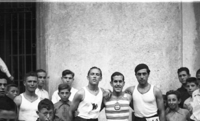 Cursa popular de la Festa Major, retrat dels corredors amb el dorsal 10, 23 i 11. El corredor amb el dorsal 23 du un equipament esportiu que recorda el de la Secció d'atletisme del RCD Espanyol.