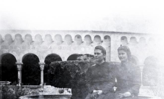 Retrat de dues noies assegudes a la font del claustre.
