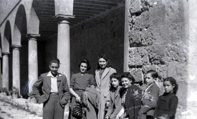 Joves retratats davant el palau abacial i el claustró.