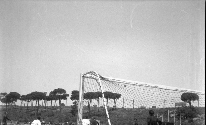 Activitats festives, partit de futbol. Ubicació no identificada, a prop hi ha una catenària d'un tren.