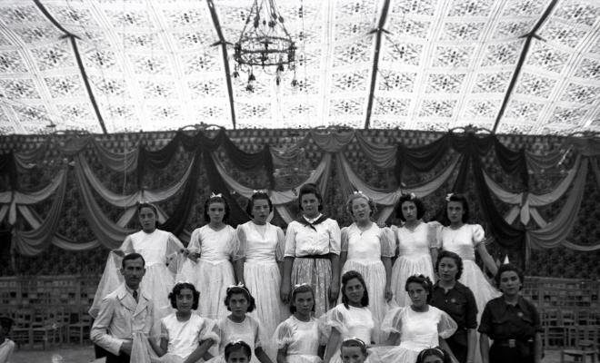 Festa Major. Ball a l'envelat, retrat d'un grup de nenes, probablement de la secció infantil de l'Esbart Dansaire, acompanyades per  Manuel Farrés i dues dones uniformades.