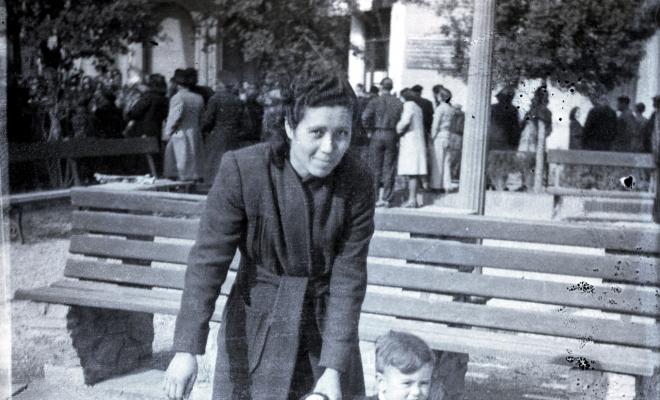 Celebració davant de la seu de la Falange a Cal Barbany. Retrat d'una dona amb un infant a la plaça del Quatre Cantons.