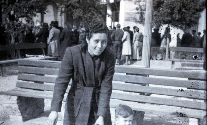 Celebració davant de la seu de la Falange a Cal Barbany. Retrat d'una dona amb un infant a la plaça del Quatre Cantons.