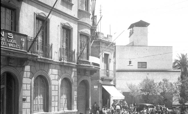 Desfilada de les parelles de balladors del Paga-li Joan al seu pas pels Quatre Cantons davant de la seu de la Central Nacional-Sindicalista.