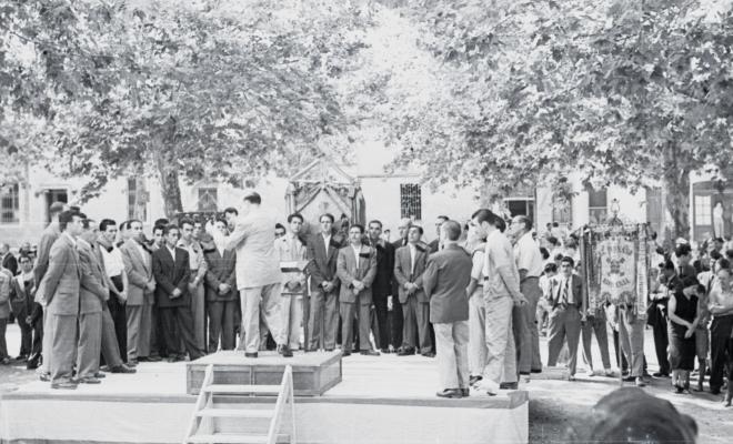 Trobada de cors Clavé, les corals a la plaça de Barcelona, la Lira, la Unió, el Parnaso Rubinense. Un dels cors actua sobre la tarima del centre de la plaça, dirigit pel Mestre Alier.