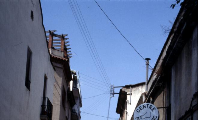 Carrer de Santa Maria, en primer terme el rètol d'un centre de podologia.