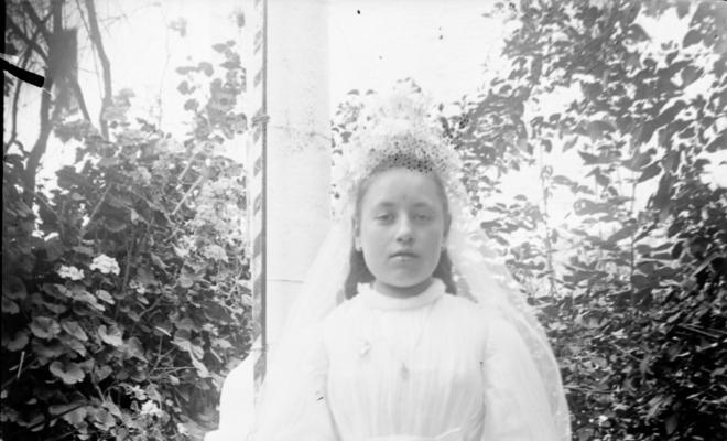 Nena de comunió al badiu o jardí
