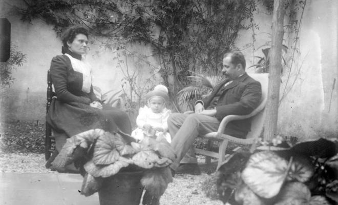 Home, dona i nena amb gorra de cop al badiu o jardí