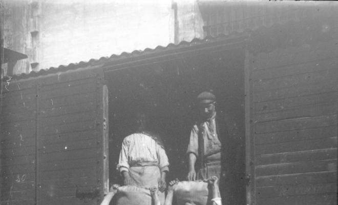 Homes descarregant sacs d'un tren
