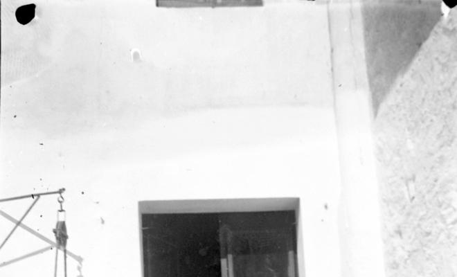 Home i tres dones al badiu davant la porta