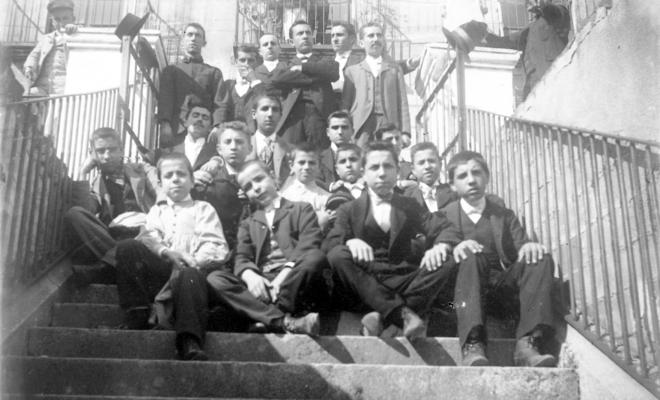 Grup d'homes i nois a una escala, a Can Real (al carrer de la Costa)