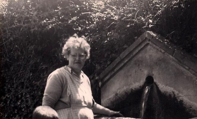 Dona i infant davant d'una font