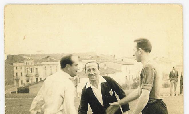 Dos jugadors es saluden al mig de l'antic camp de futbol de Montornès del Vallès davant de la presència de l'àrbitre del partit