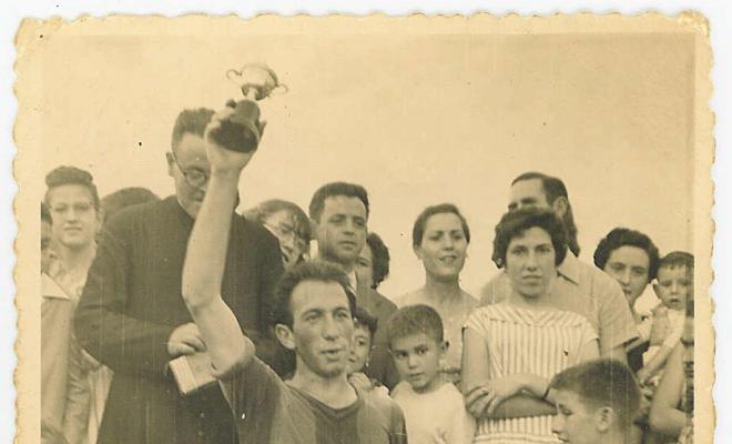 Capità de l'equip de futbol de Montornès del Vallès aixecant el trofeu davant de la gent