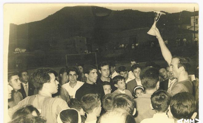 Capità de l'equip de futbol de Montornès del Vallès aixecant el trofeu amb el seu equip i l'afició
