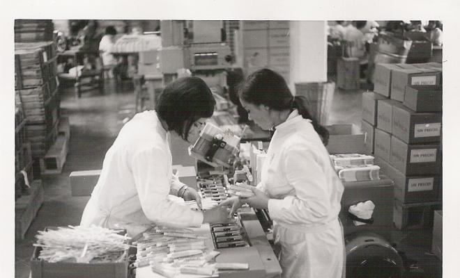 Dues dones treballant amb una màquina de producció de l'empresa Cydsa-Vitamol