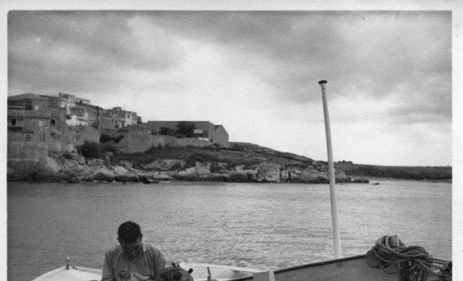 Un pescador sobre la barca varada a la zona de l'Escala (Alt Empordà)