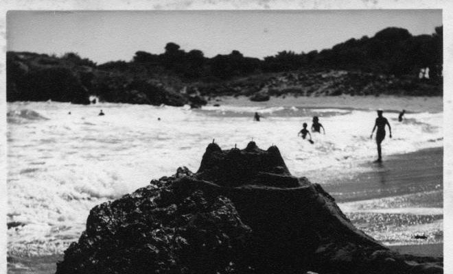 Vista d'una platja de l'Escala (Alt Empordà) on hi ha alguns banyistes