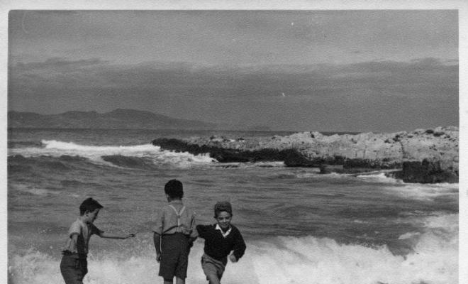 Tres nens jugant a una platja de l'Escala (Alt Empordà)