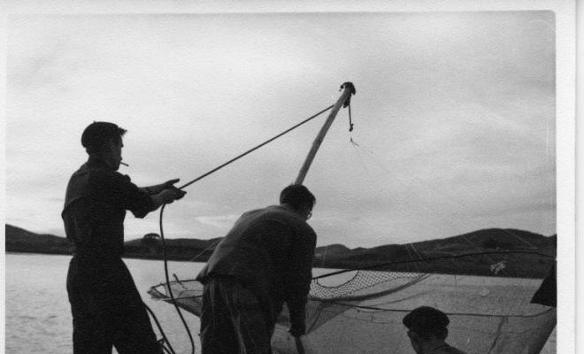 Grup de pescadors estirant una xarxa des del port de Santoña (Cantàbria)