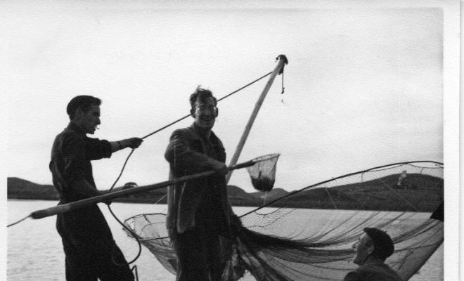Grup de pescadors estirant una xarxa des del port de Santoña (Cantàbria)