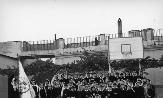 Foto de grup de les alumnes de les Escolàpies amb uniforme i mantellina